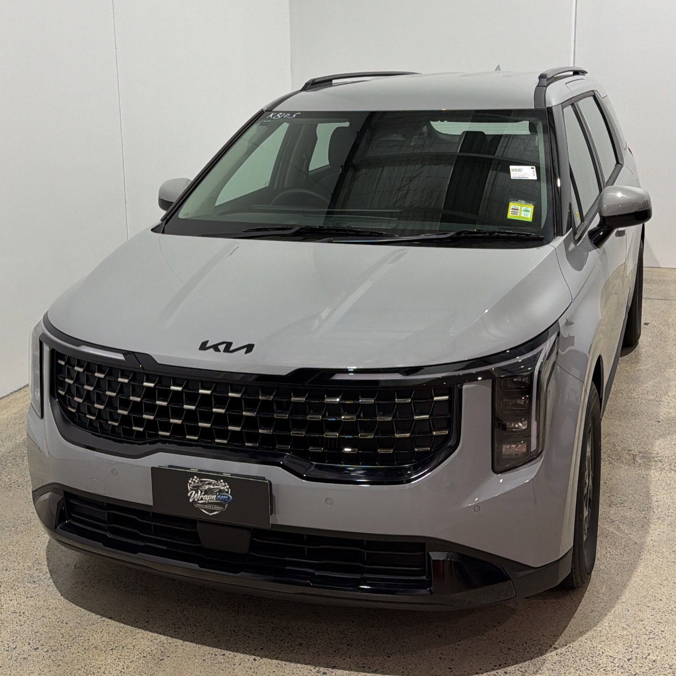 2026 Kia Carnival wrapped in Gloss Obsidian Black, shot 2